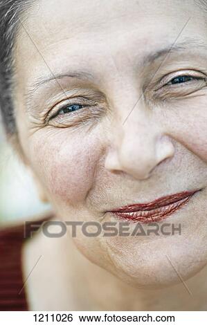 Stock Photograph - A mature woman smiling cheerfully, close-up. Fotosearch