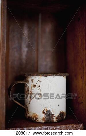 A metal cup on a wooden shelf View Large Photo Image Stock Photo - A metal cup on a wooden shelf. Fotosearch