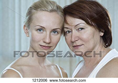 A mother with her adult daughter looking serenely into the camera View Large Photo Image Stock Photograph - A mother with her adult daughter looking serenely into the camera. Fotosearch