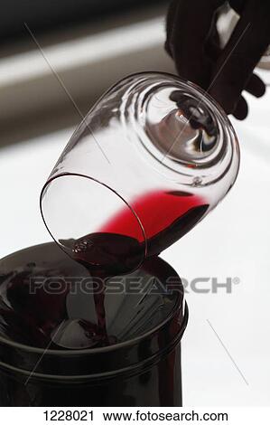 A person pouring red wine out of a wineglass into a spittoon at a wine tasting View Large Photo Image Stock Image - A person pouring red wine out of a wineglass into a spittoon at a wine tasting. Fotosearch