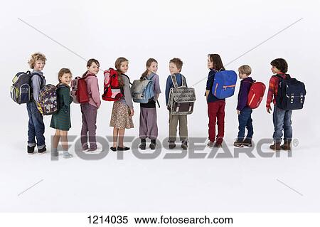 Stock Photography - A row of school children wearing backpacks and standing in a row. Fotosearch