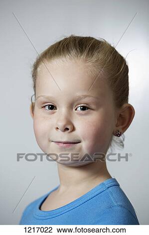 A serene young girl smiling into the camera View Large Photo Image Stock Image - A serene young girl smiling into the camera. Fotosearch