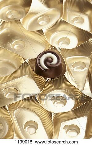 Stock Photography - A single chocolate in a box. Fotosearch