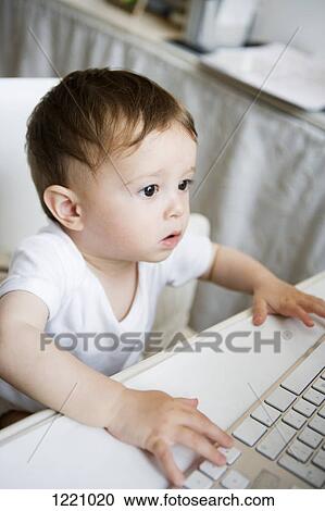 Stock Image - A toddler using a computer keyboard. Fotosearch