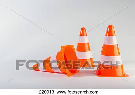 Stock Image - A traffic cone lying on its side next to two standing traffic cones. Fotosearch