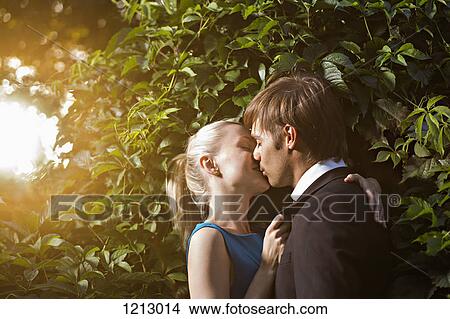 A well-dressed couple kissing in a park View Large Photo Image Picture - A well-dressed couple kissing in a park. Fotosearch