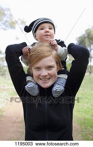 A woman holding a baby boy on her shoulders View Large Photo Image Stock Image - A woman holding a baby boy on her shoulders. Fotosearch