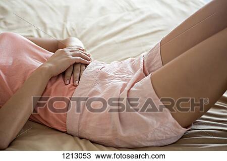 A woman lying on a bed comfortably, midsection View Large Photo Image Stock Image - A woman lying on a bed comfortably, midsection. Fotosearch
