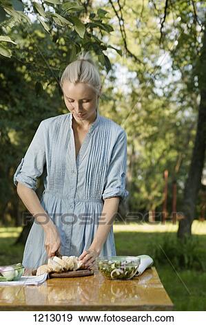 A woman preparing a healthy meal outdoors in the backyard View Large Photo Image Stock Photo - A woman preparing a healthy meal outdoors in the backyard. Fotosearch