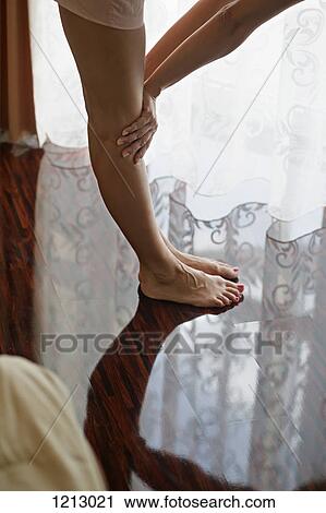 A woman stretching on a hardwood floor, waist down View Large Photo Image Stock Image - A woman stretching on a hardwood floor, waist down. Fotosearch
