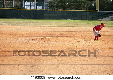 Stock Photo - A young baseball player on a baseball diamond. Fotosearch