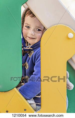 A young boy climbing the stairs of a slide at a playground View Large Photo Image Picture - A young boy climbing the stairs of a slide at a playground. Fotosearch