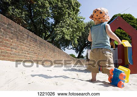 A young boy contemplating his choices at a playground View Large Photo Image Stock Photograph - A young boy contemplating his choices at a playground. Fotosearch