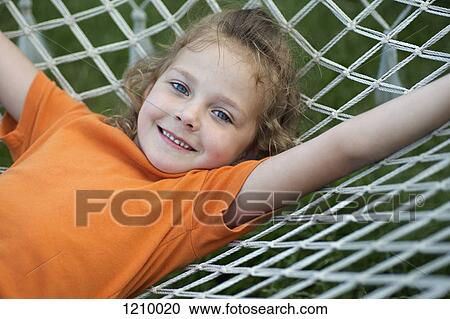 A young cheerful girl lying on a hammock View Large Photo Image Stock Image - A young cheerful girl lying on a hammock. Fotosearch