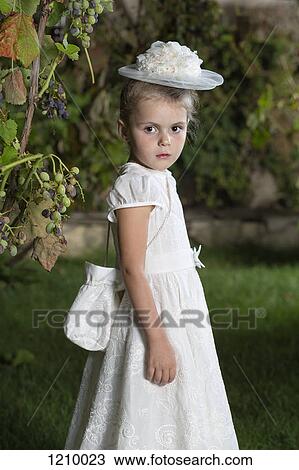 A young girl dressed elegantly in a white dress, hat and purse View Large Photo Image Stock Image - A young girl dressed elegantly in a white dress, hat and purse. Fotosearch