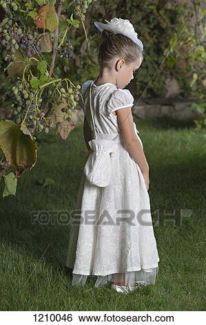 A young girl dressed elegantly in a white dress and hat and carrying a purse View Large Photo Image Stock Photograph - A young girl dressed elegantly in a white dress and hat and carrying a purse. Fotosearch