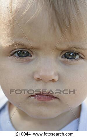 Picture - A young girl frowning in concentration, close-up of face. Fotosearch
