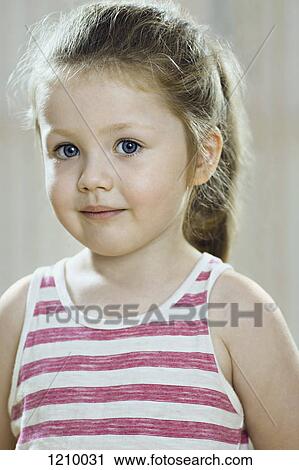 A young girl wearing a striped tank top and looking shyly into the camera View Large Photo Image Stock Image - A young girl wearing a striped tank top and looking shyly into the camera. Fotosearch