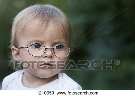 A young girl wearing glasses frowns in concentration while looking away View Large Photo Image Stock Photo - A young girl wearing glasses frowns in concentration while looking away. Fotosearch
