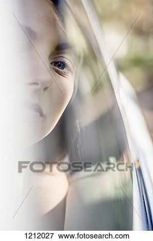 A young woman in a stationary car looking serenely out the window View Large Photo Image Stock Photo - A young woman in a stationary car looking serenely out the window. Fotosearch