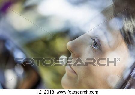 A young woman looking thoughtfully out the window of a stationary car View Large Photo Image Stock Photo - A young woman looking thoughtfully out the window of a stationary car. Fotosearch