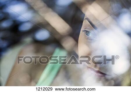 Stock Photo - A young woman looking thoughtfully out the window of a stationary car. Fotosearch