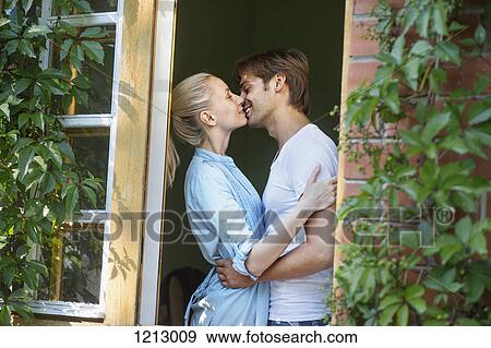 Stock Photo - An affectionate couple kissing in a doorway. Fotosearch