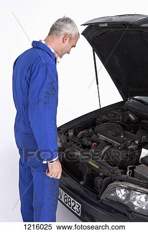 An auto mechanic looking under the hood of a car thoughtfully View Large Photo Image Stock Photography - An auto mechanic looking under the hood of a car thoughtfully. Fotosearch