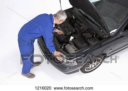 An auto mechanic working on a broken car View Large Photo Image Stock Image - An auto mechanic working on a broken car. Fotosearch