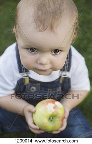 Picture - Baby holding apple. Fotosearch