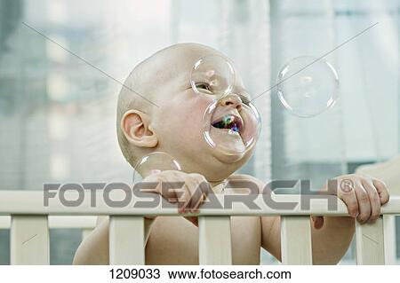 Baby in cot enjoying the bubbles View Large Photo Image Stock Image - Baby in cot enjoying the bubbles. Fotosearch