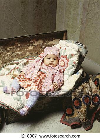 Baby on embroidered blankets on wooden chest View Large Photo Image Stock Photo - Baby on embroidered blankets on wooden chest. Fotosearch