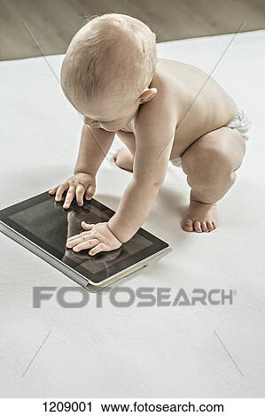 Baby playing with a digital tablet View Large Photo Image Stock Image - Baby playing with a digital tablet . Fotosearch