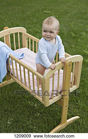 Baby standing in cot outside View Large Photo Image Stock Photo - Baby standing in cot outside. Fotosearch