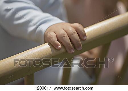 Stock Photo - Baby's hand on crib railing. Fotosearch