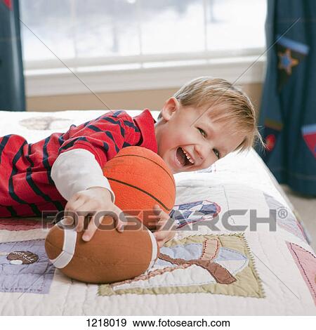 Boy playing on bed View Large Photo Image Stock Photo - Boy playing on bed. Fotosearch