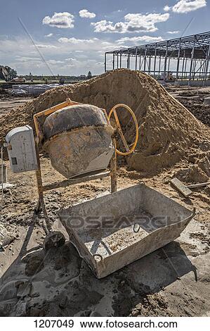 Cement mixer and sand heap at construction site View Large Photo Image Stock Photo - Cement mixer and sand heap at construction site. Fotosearch