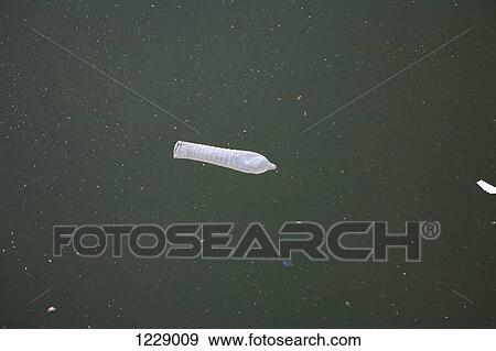 Condom floating on dirty river View Large Photo Image Stock Photo - Condom floating on dirty river. Fotosearch
