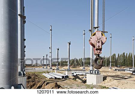 Stock Image - Crane hook among steel beams of construction frame. Fotosearch