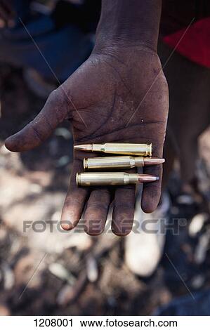 Detail of a man holding three bullets View Large Photo Image Stock Image - Detail of a man holding three bullets. Fotosearch