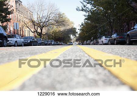 Stock Photograph - Dividing line leading to approaching car in background. Fotosearch