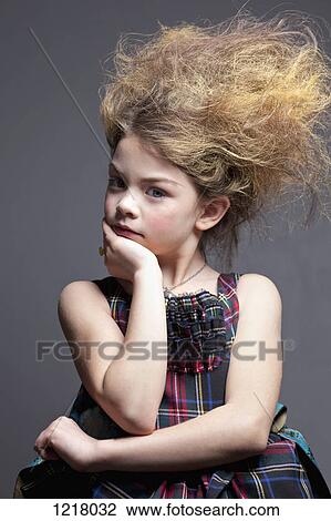 Stock Image - Dressed up girl in tartan dress with hair back. Fotosearch