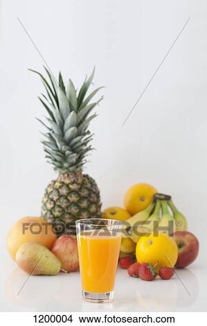 Picture - Glass of orange juice with the fruity ingredients in the background. Fotosearch