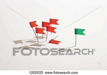 Stock Image - Green flag standing apart from red flags. Fotosearch