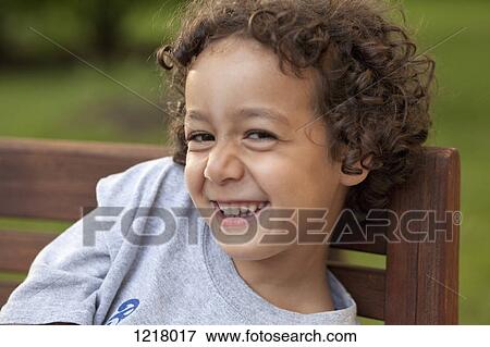 Stock Photo - Happy boy on bench. Fotosearch