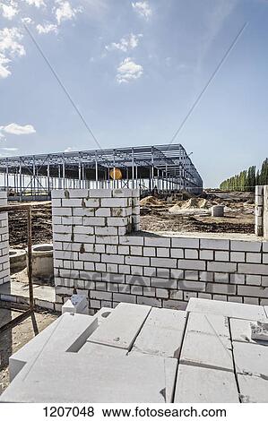 Incomplete brick wall with construction frame in background of construction site View Large Photo Image Stock Photo - Incomplete brick wall with construction frame in background of construction site. Fotosearch