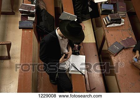 Jewish man holding tefillin in synagogue View Large Photo Image Stock Photo - Jewish man holding tefillin in synagogue . Fotosearch