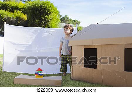 Kid standing beside cardboard playhouse View Large Photo Image Stock Photo - Kid standing beside cardboard playhouse. Fotosearch