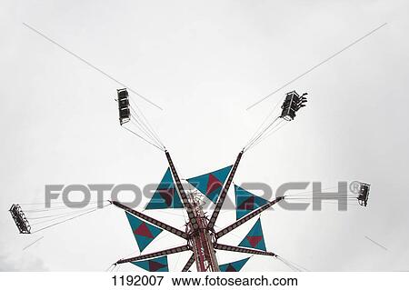 Stock Photo - Low angle view of a fairground swing ride. Fotosearch