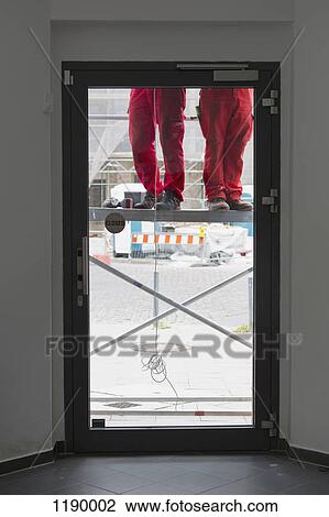 Low section of two construction workers on scaffolding View Large Photo Image Stock Image - Low section of two construction workers on scaffolding. Fotosearch